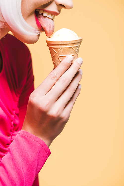cropped view of happy girl eating ice cream, isolated on yellow