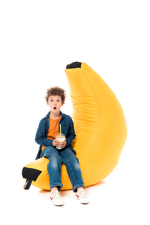 유토이미지 | shocked child in jeans sitting on bean bag chair and holding ...