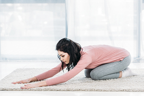 beautiful woman practicing balasana pose in Living Room at home