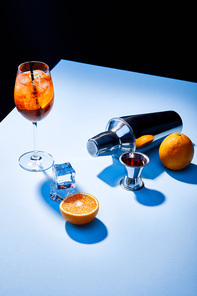 Aperol Spritz, oranges, shaker, ice cubes and measuring cup