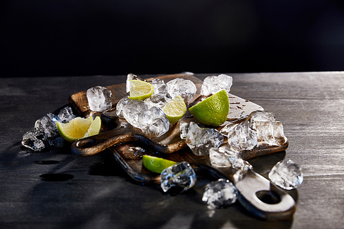 ice cubes and cut limes on wooden cutting boards
