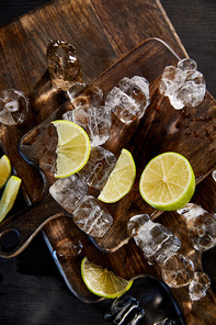 top view of ice cubes and cut limes on wooden cutting boards