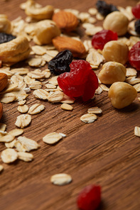close up of oat flakes with dried berries and hazelnuts on wooden table