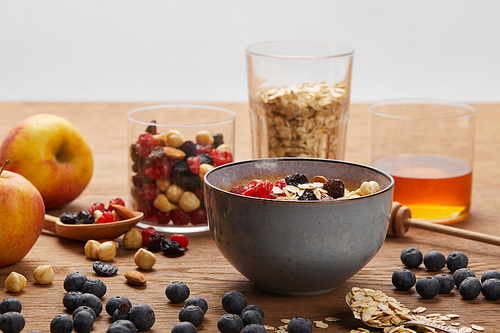 berries, nuts and muesli for breakfast on wooden table isolated on grey