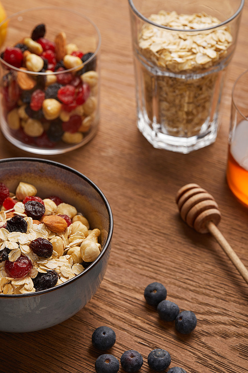 selective focus of cereal in bowl with nuts and dried berries prepared for breakfast