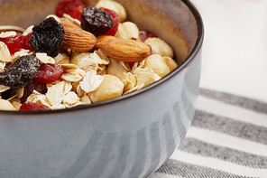 close up of bowl with muesli on striped napkin