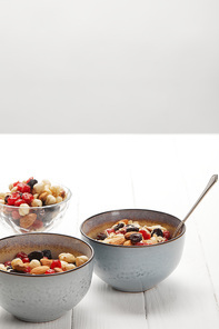 bowls with muesli, dried berries and nuts served for breakfast isolated on grey