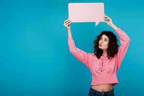 attractive curly girl with duck face holding pink speech bubble on blue
