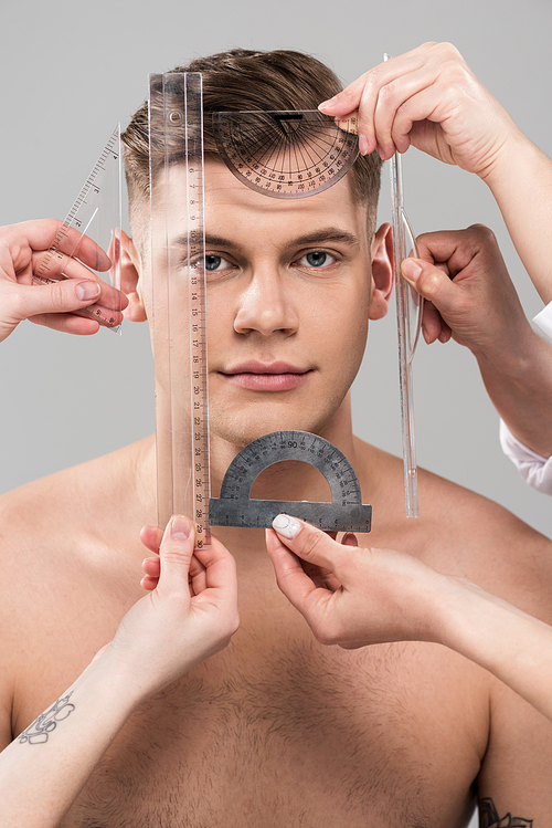 cropped view of plastic surgeons measuring face with rulers and protractors isolated on grey