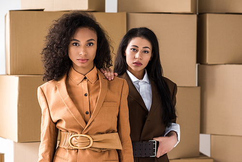 stylish african american women  near cardboard boxes