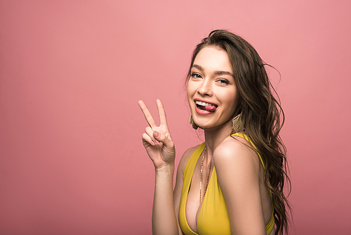 pretty young woman in yellow swimsuit showing peace sign isolated on pink