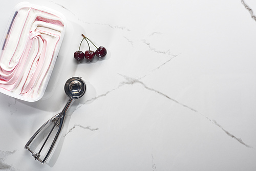 top view of delicious cherries and ice cream on marble grey background with ice cream spoon