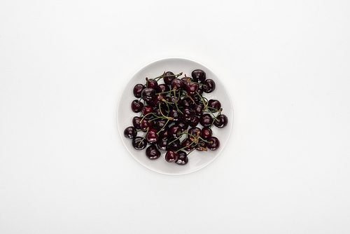 top view of red and ripe cherries on white plate