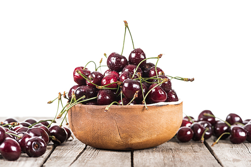 red, fresh, whole and ripe cherries covered with droplets on bowl on wooden table