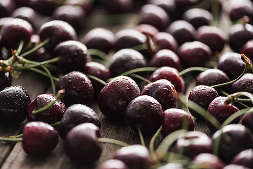 selective focus of fresh, whole and ripe cherries on wooden surface