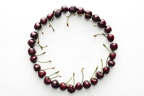 flat lay with fresh, whole and ripe cherries covered with water drops