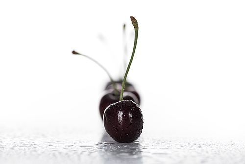 selective focus of red, whole and ripe cherries covered with droplets