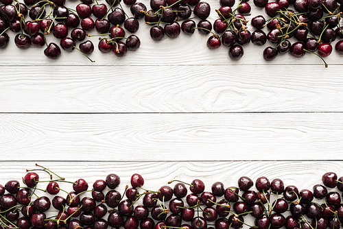 top view of fresh, sweet and washed cherries on wooden background