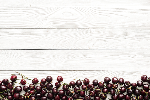 top view of fresh, sweet and wet cherries on wooden background with copy space