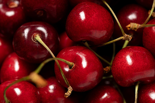 close up view of red delicious shiny cherries