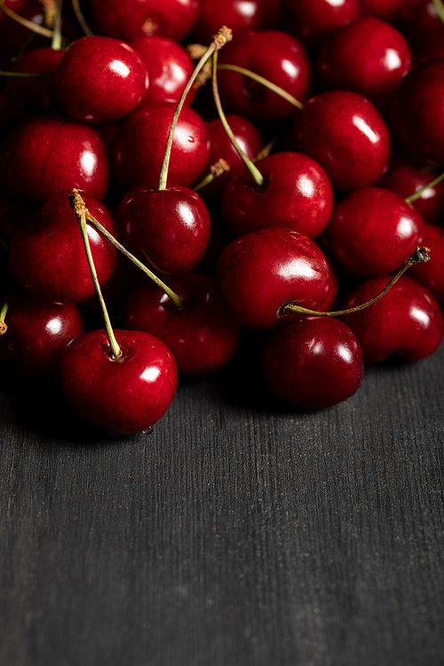 red delicious cherries scattered on wooden dark table