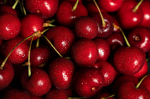 top view of red delicious and ripe cherries with water drops