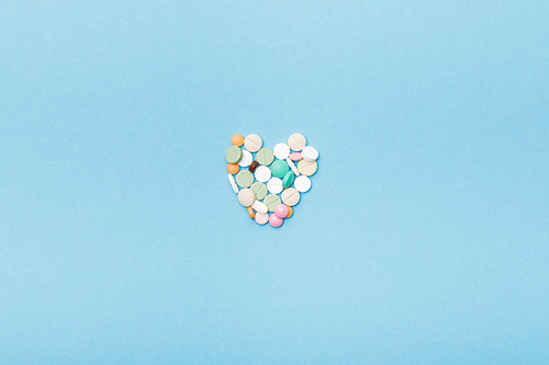 Flat lay with colorful pills on blue surface