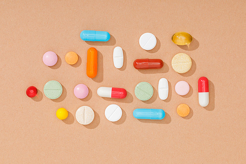 Top view of colorful pills on brown surface