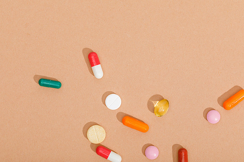Top view of colorful pills on brown surface
