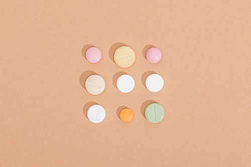Flat lay with colorful pills on brown surface