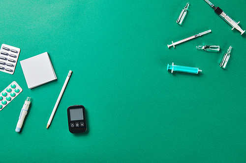 various medical supplies with sticky notes and pencil on green bakground