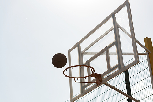 ball and basketball hoop under sky in sunny day