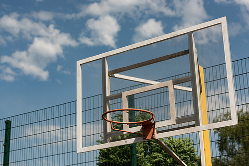 basketball hoop at basketball court under blue cloudy sky