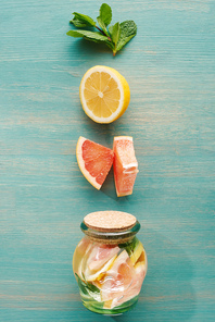 top view of detox drink in jar with lemons, grapefruits and mint