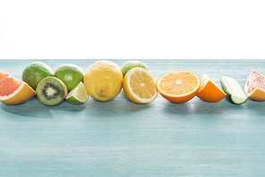 Fresh juicy fruits and cucumber on blue textured surface