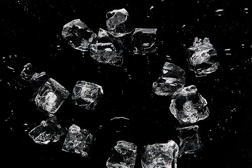 top view of melting transparent refreshing ice cubes isolated on black