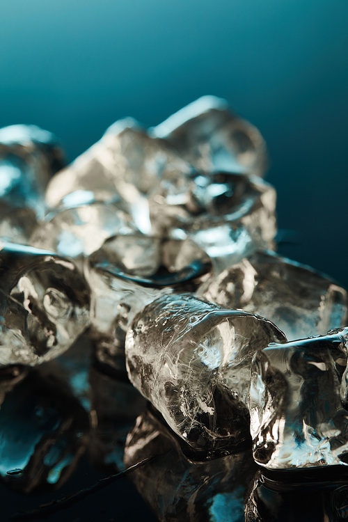 close up view of clear ice cubes on emerald background