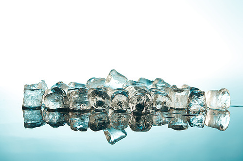 stack of transparent ice cubes on emerald and white background