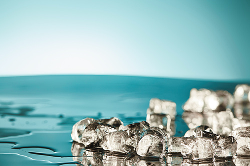 transparent melting ice cubes on emerald and white background