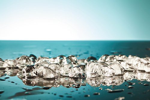 fresh melting ice cubes on emerald and white background