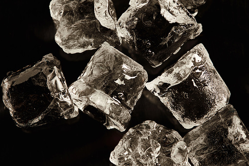 stack of transparent cool ice cubes isolated on black