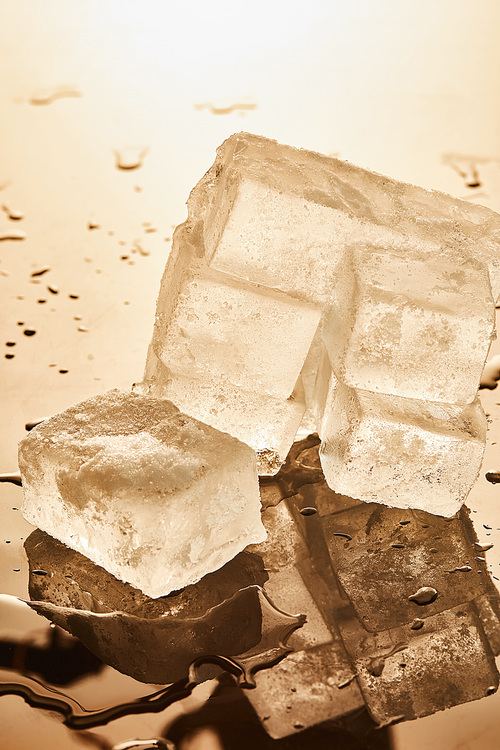 stack of ice cubes with puddles on illuminated background