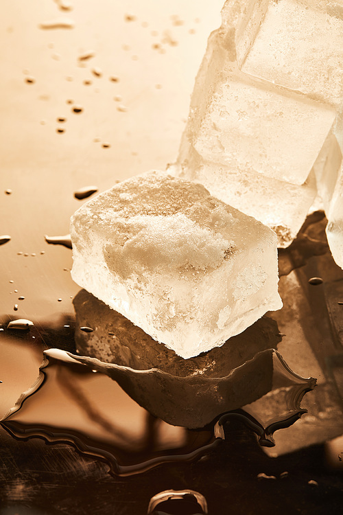 stack of ice cubes with puddles on surface with reflection