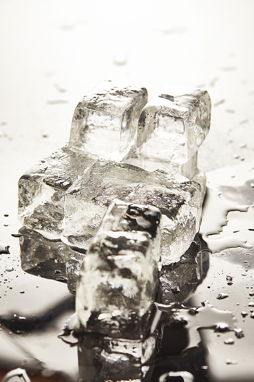 pure melting ice cubes with drops and puddles on surface