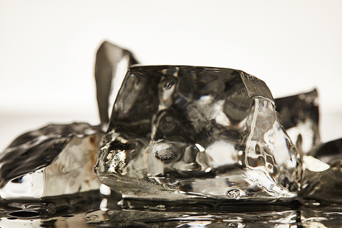 close up view of transparent melting ice cubes on white background