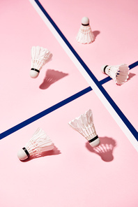 Badminton shuttlecocks on pink surface with blue lines