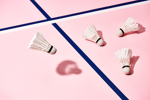 White badminton shuttlecocks on pink background with blue lines