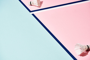 Badminton shuttlecocks on pink and blue background with lines
