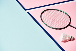 Badminton racket and shuttlecock on colorful surface with blue lines
