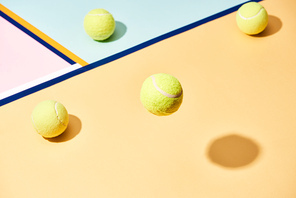High angle view of tennis balls with shadow on colorful background with blue lines